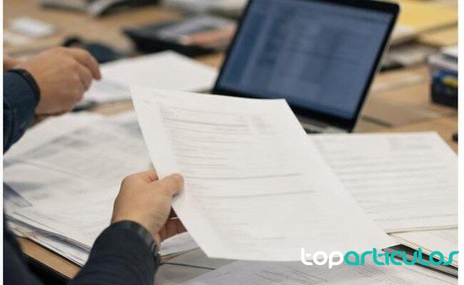 Documentación y portátil revisados en una oficina de investigación