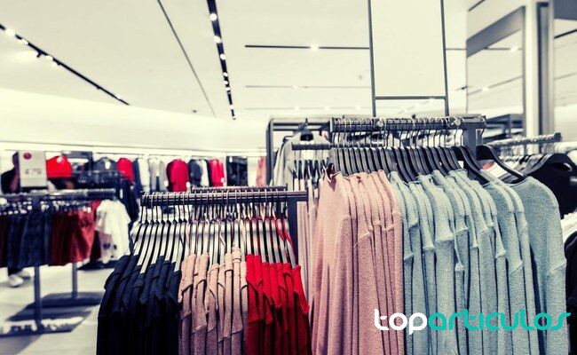 Revisión de prendas antes de decidir compras de temporada persona organizando ropa de verano en un armario