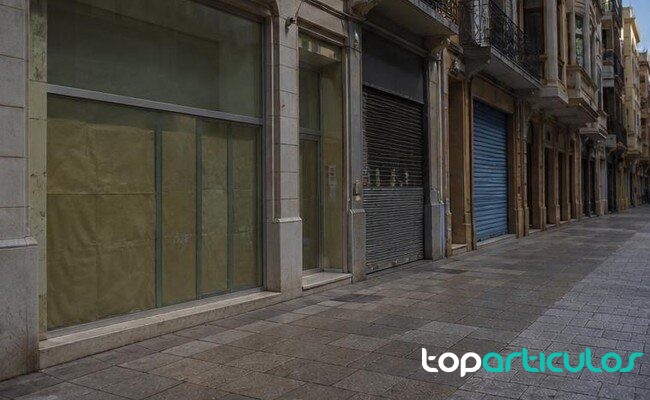 Locales comerciales y pulso empresarial Distrito comercial español con escaparates neutros y sin marcas visibles