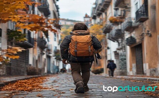 Persona caminando con mochila pequeña por una ciudad en otoño equipaje ligero para viajar sin coche