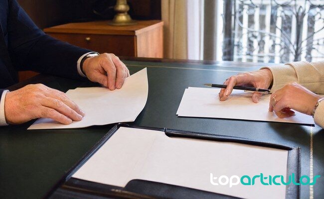 Documentación de una hipoteca revisada sobre una mesa Firma de documentación hipotecaria sin textos legibles