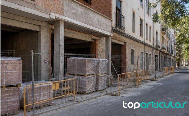 Edificio residencial en obras con materiales apilados en una calle española