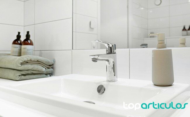 Lavabo con toallas y dispensadores neutros para una limpieza facial respetuosa limpieza facial suave sin irritar