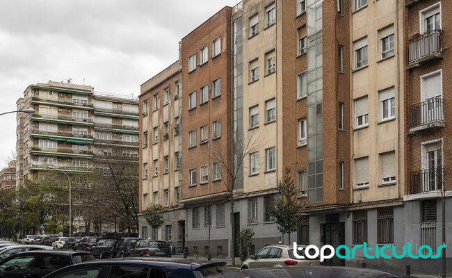 Vivienda eleva a 317 las zonas tensionadas de alquiler en España Bloques residenciales en una calle urbana ante las nuevas zonas tensionadas de alquiler